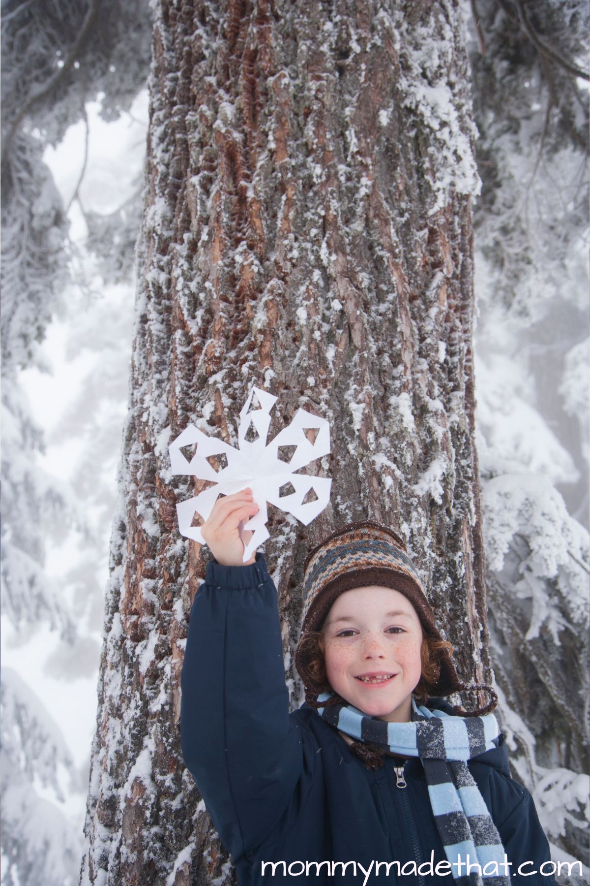 Holiday bucket list ideas, child holding paper snowflake