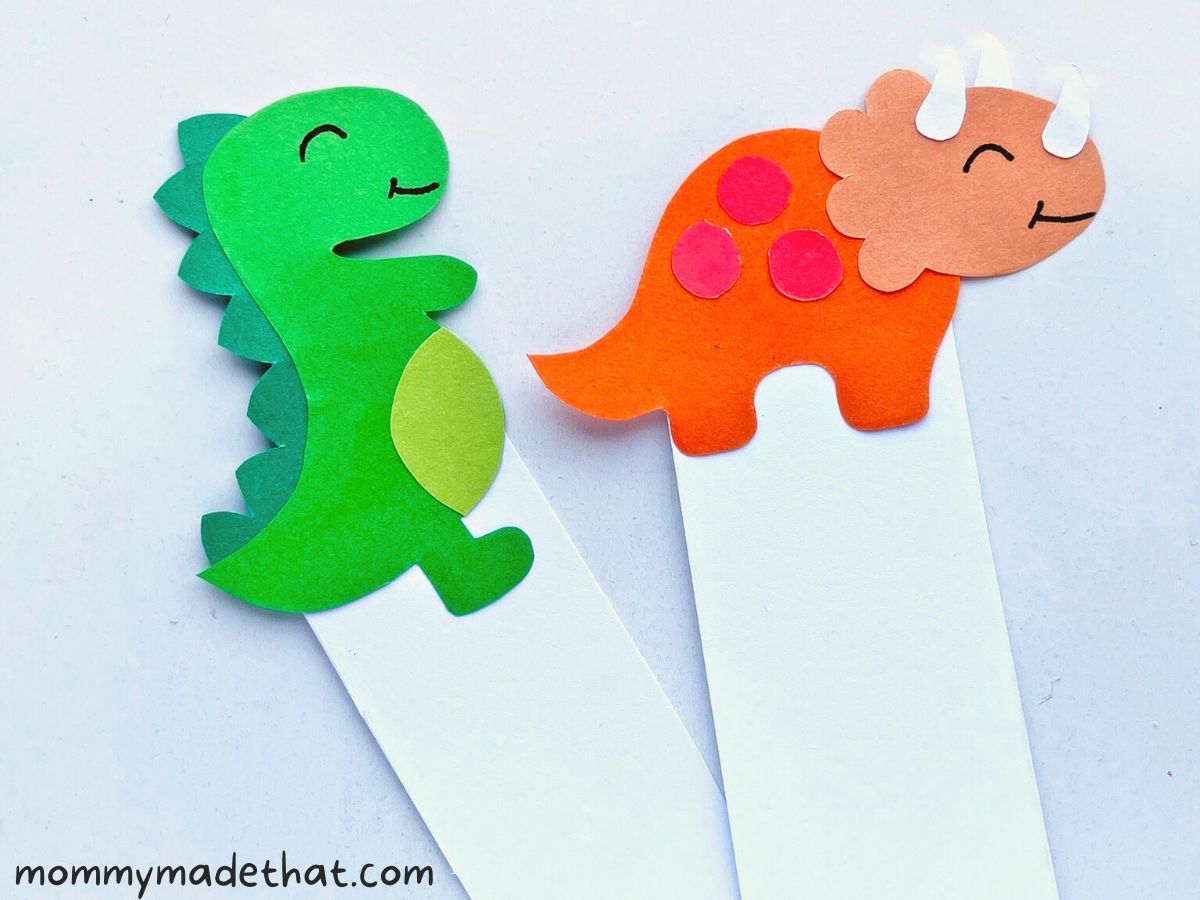 attaching the paper dinosaurs to bookmarks