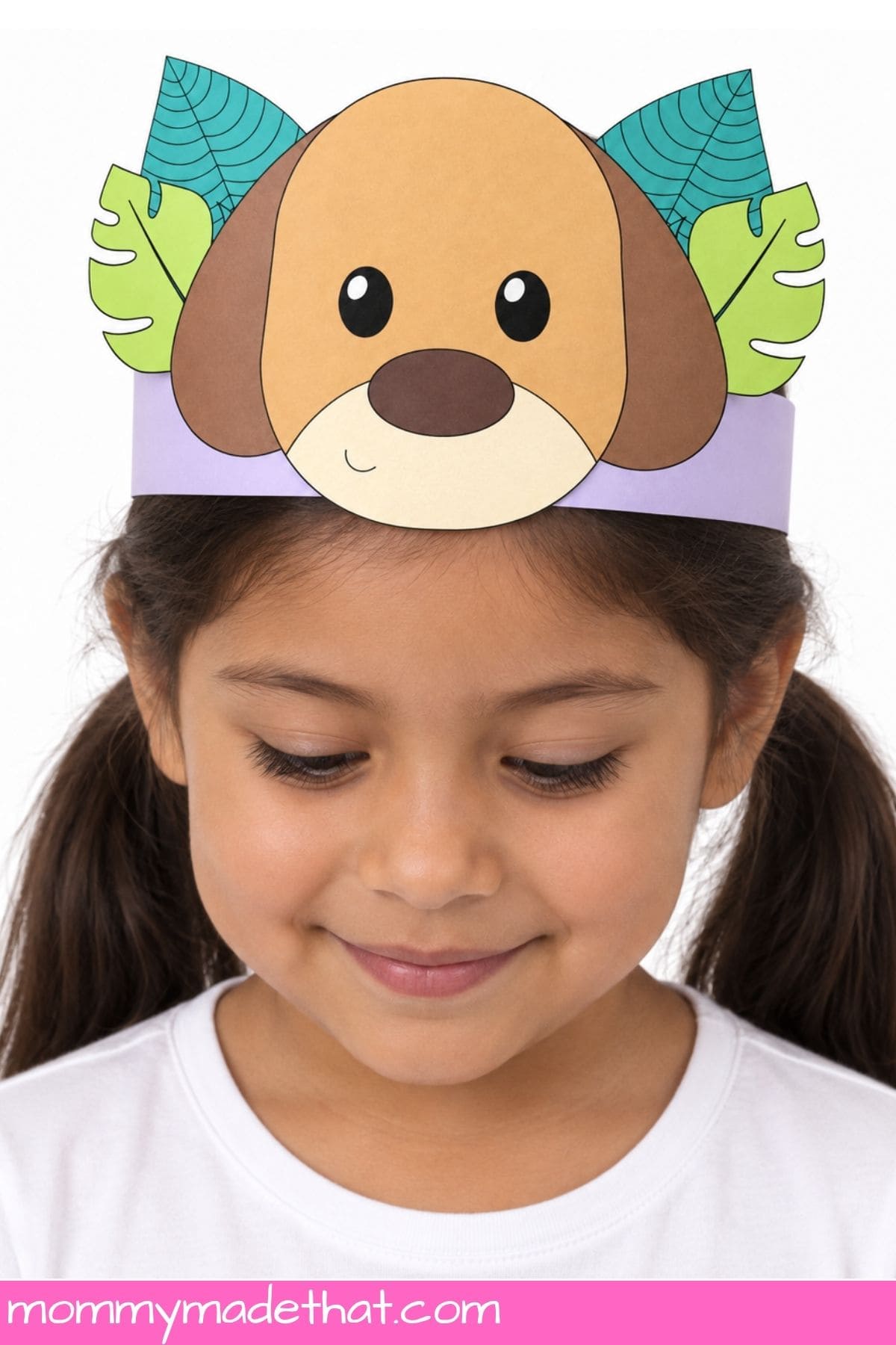 Child wearing a paper dog crown with brown floppy ears and teal and lime leaves