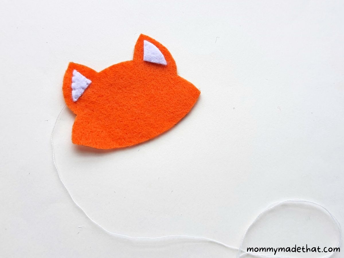 sewing ears onto felt fox ornament 