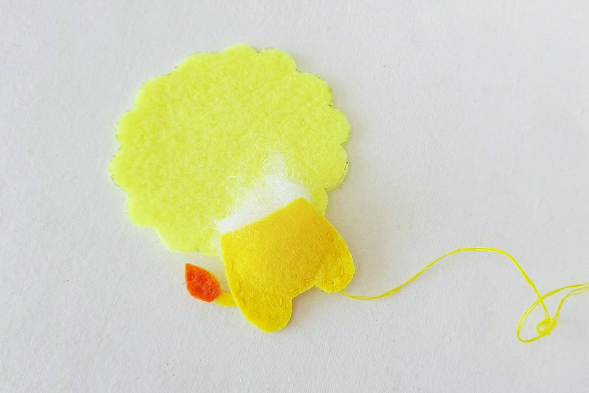 Cotton stuffing placed inside the stitched yellow felt lion body