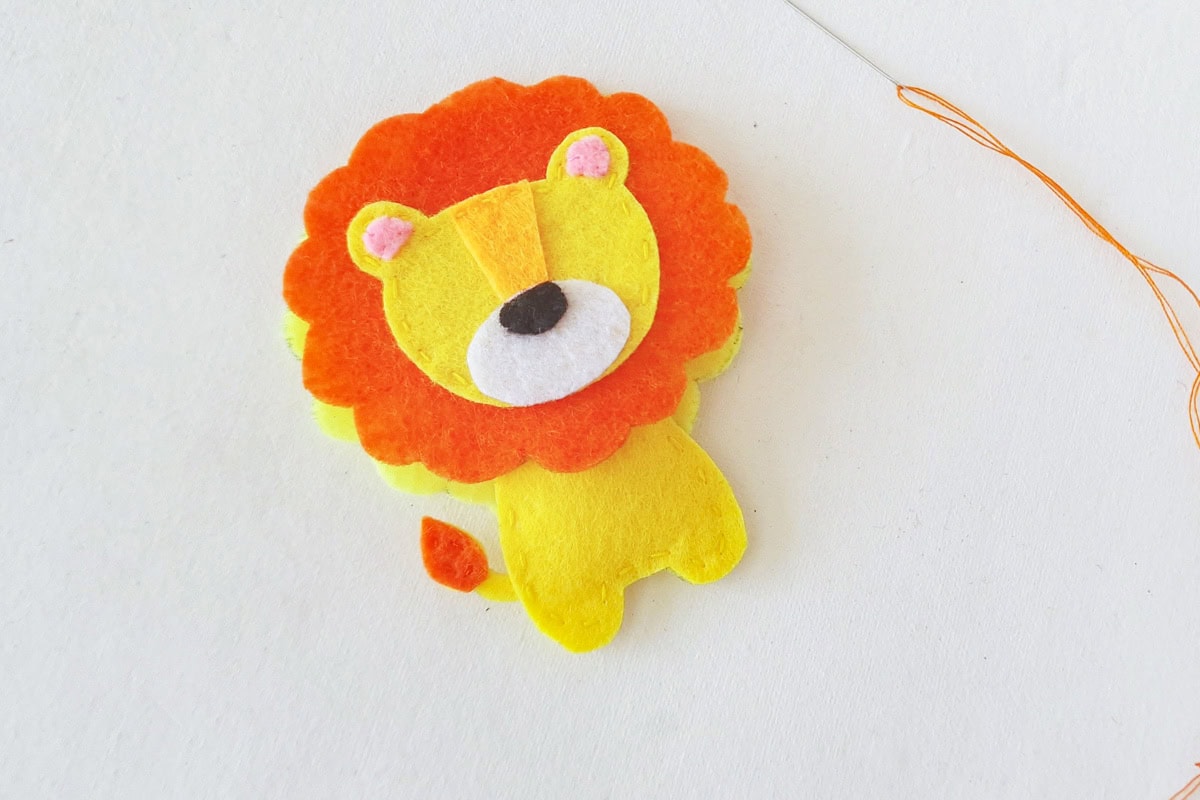 Finished lion face and orange mane placed over the yellow body