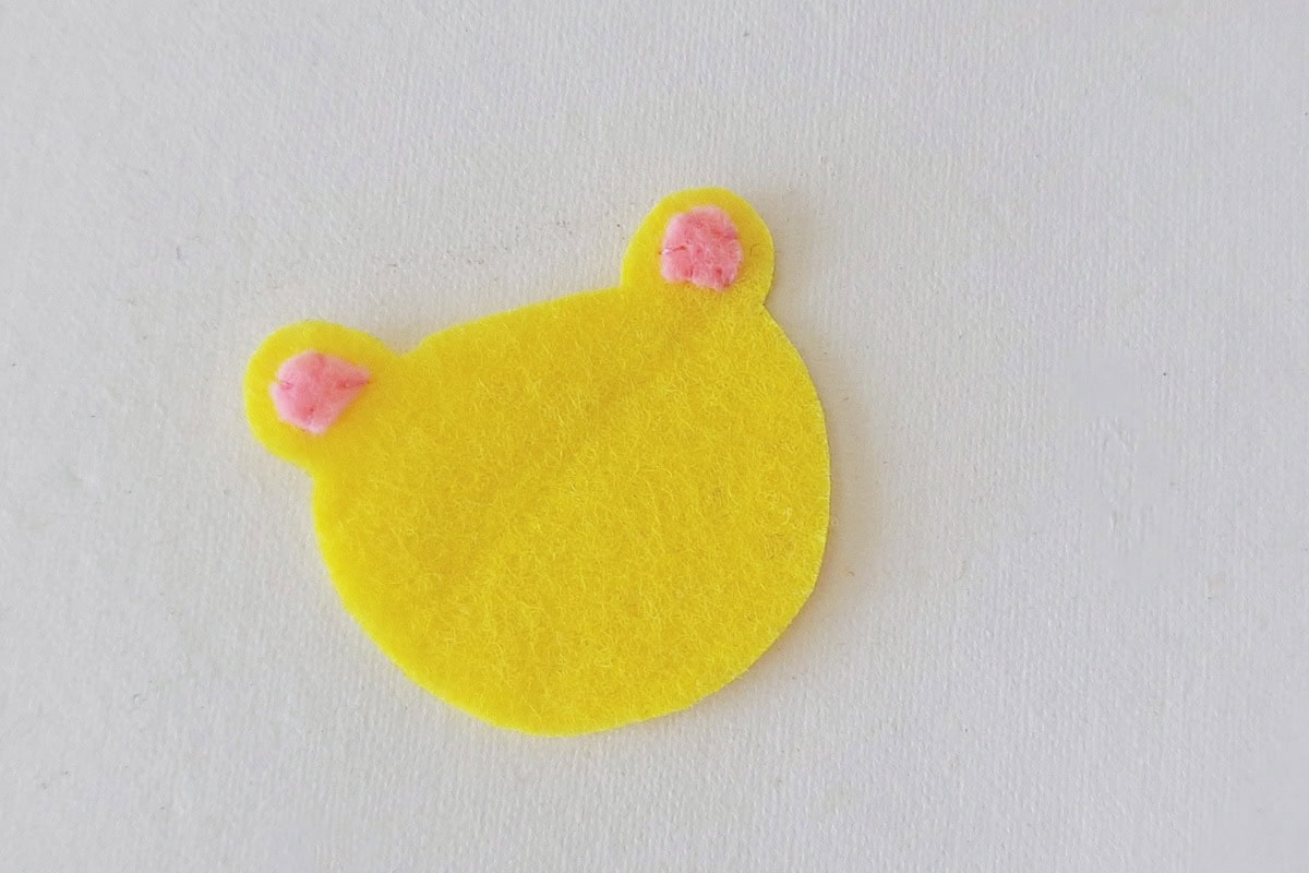 Pink felt inner ears stitched onto the yellow lion head