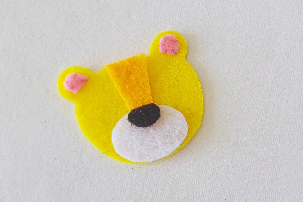 White felt muzzle and black nose attached to the yellow lion face