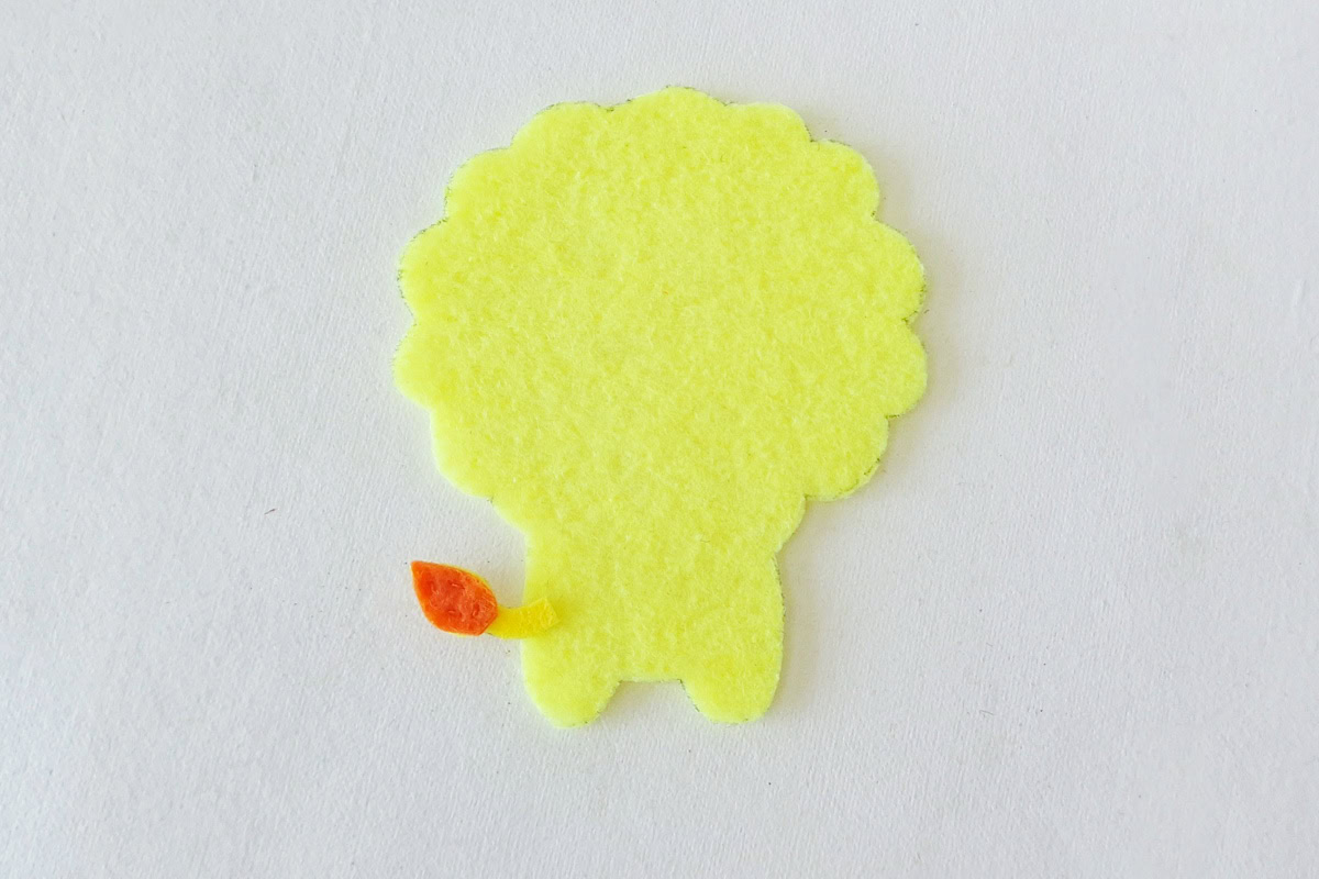 Orange-tipped felt tail attached to the side of the lion body base