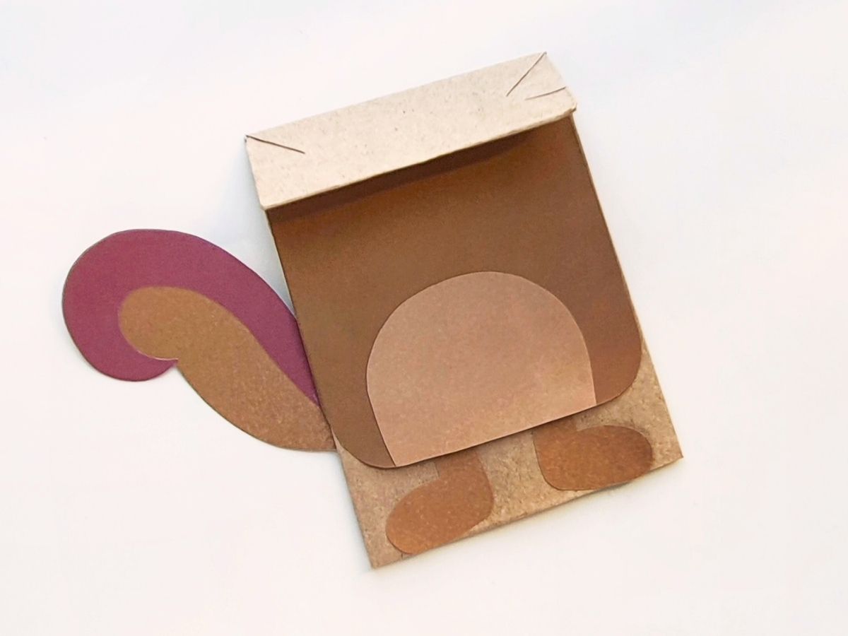 Adding body pieces to paper bag.