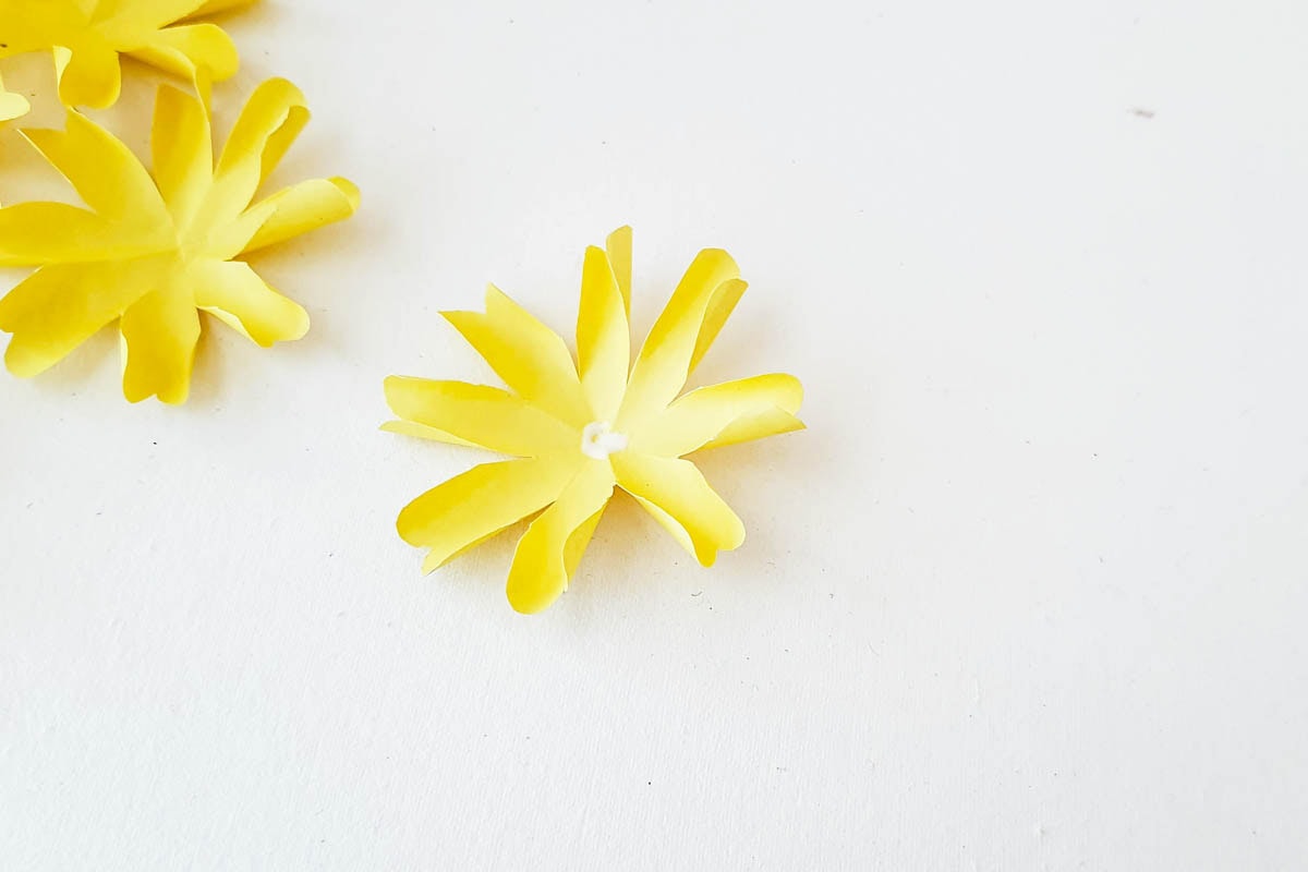 Adding glue to center of flower petals.