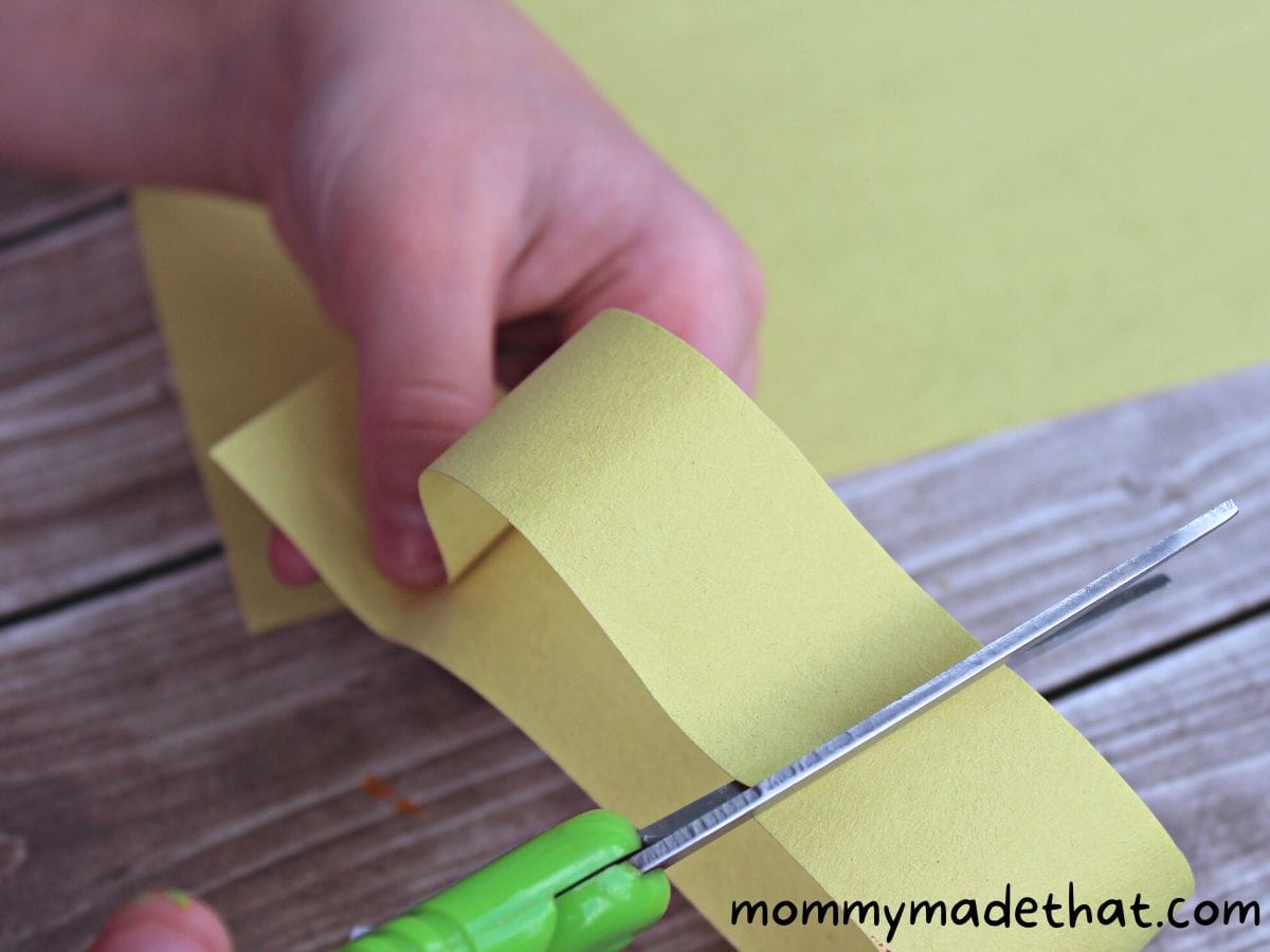 cutting yellow strips of paper for the sunflower petals