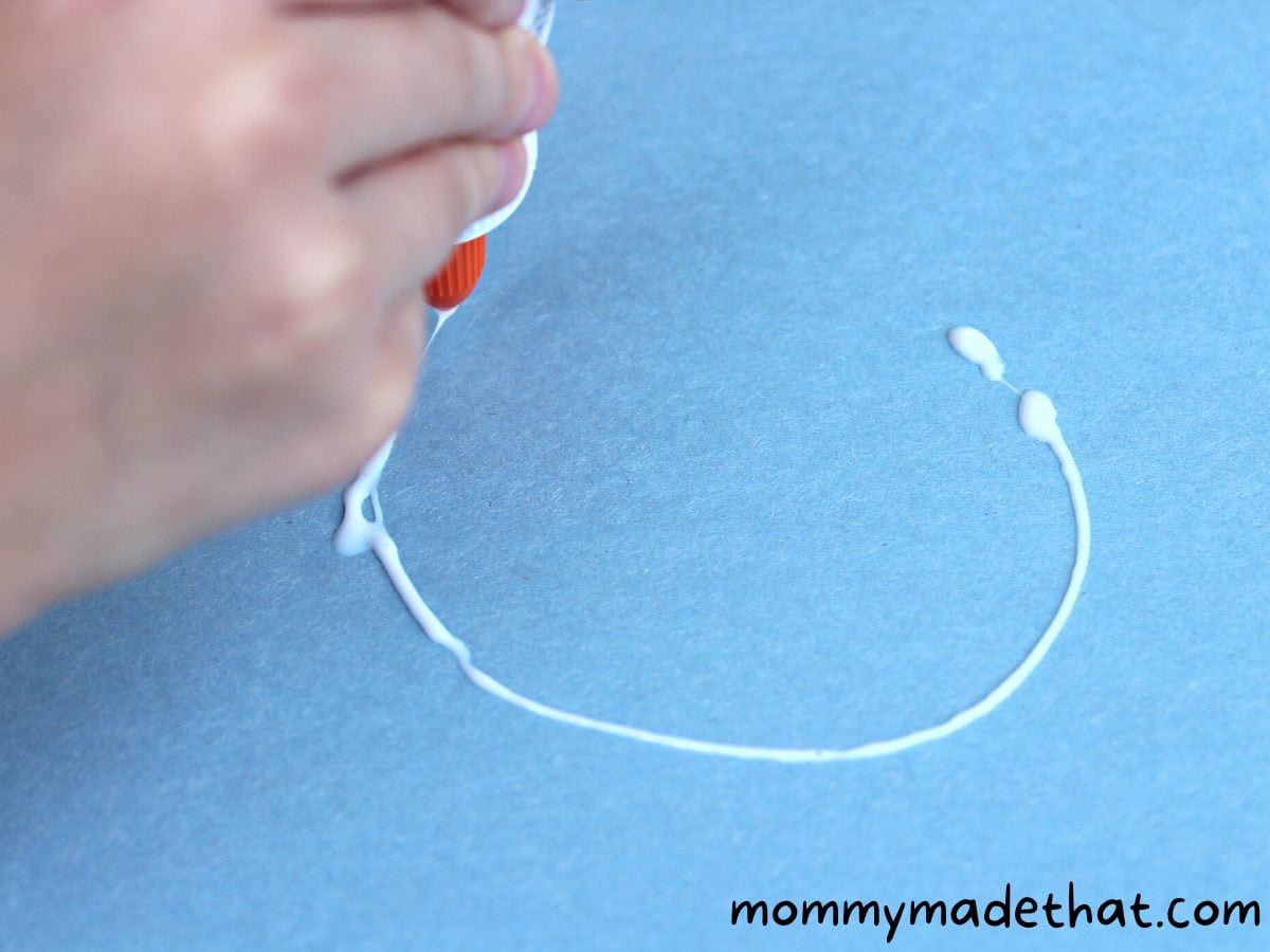 making a circle of glue on paper