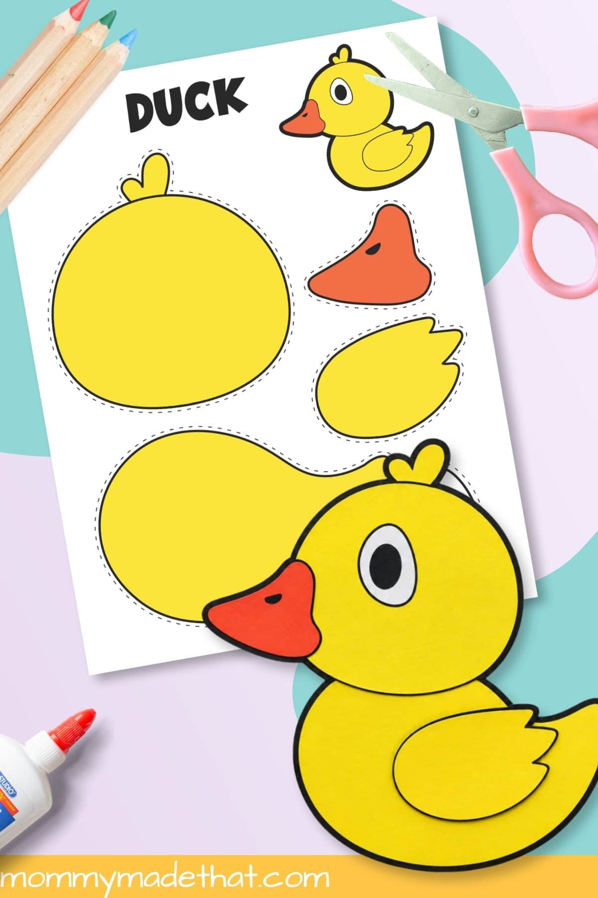 Assembled duck printable craft beside scissors and template