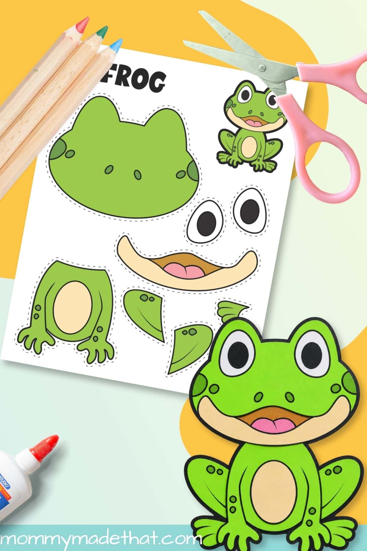 Assembled frog printable craft beside scissors and template