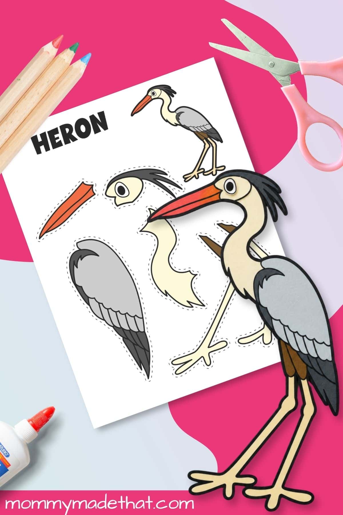 Assembled heron printable craft beside scissors and template
