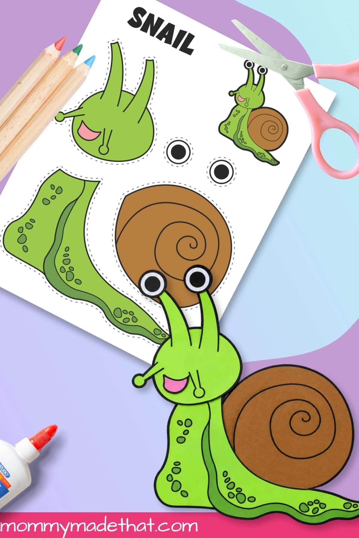 Assembled snail printable craft beside scissors and template
