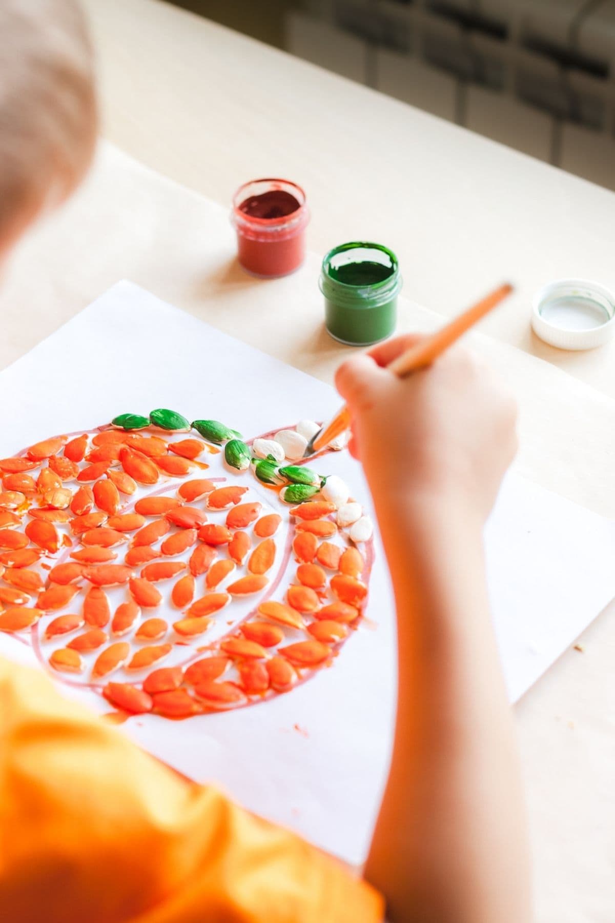 pumpkin outline filled with pumpkin seeds craft for kids