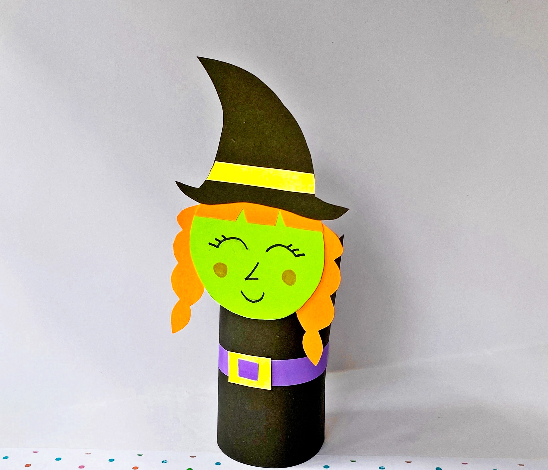 attaching witch head to toilet paper roll witch
